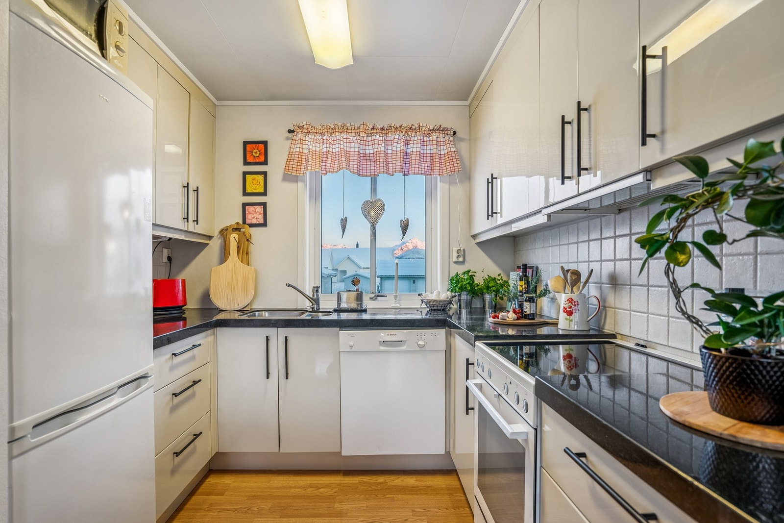 Kjøkkeninnredning med lyse fronter og laminat benkeplate. Galleribilde