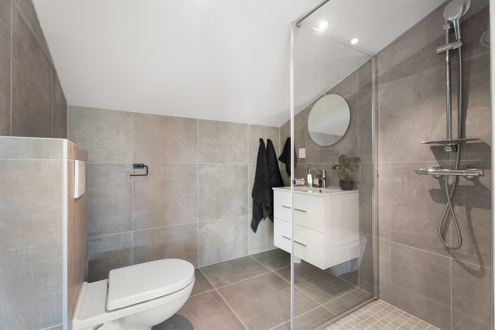 Et pent, flislagt bad i samme stil som badet i 2. etasje. Perfekt om man har gjester. Galleribilde