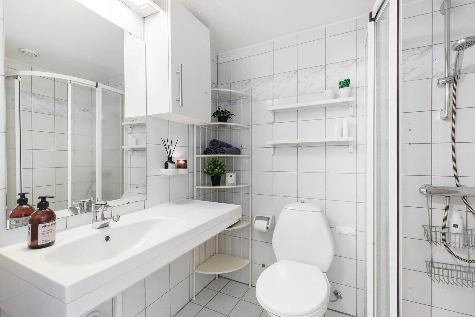 Lyst, flislagt bad på 3 kvm med flere oppbevaringsløsninger i form av skap og hyller Galleribilde