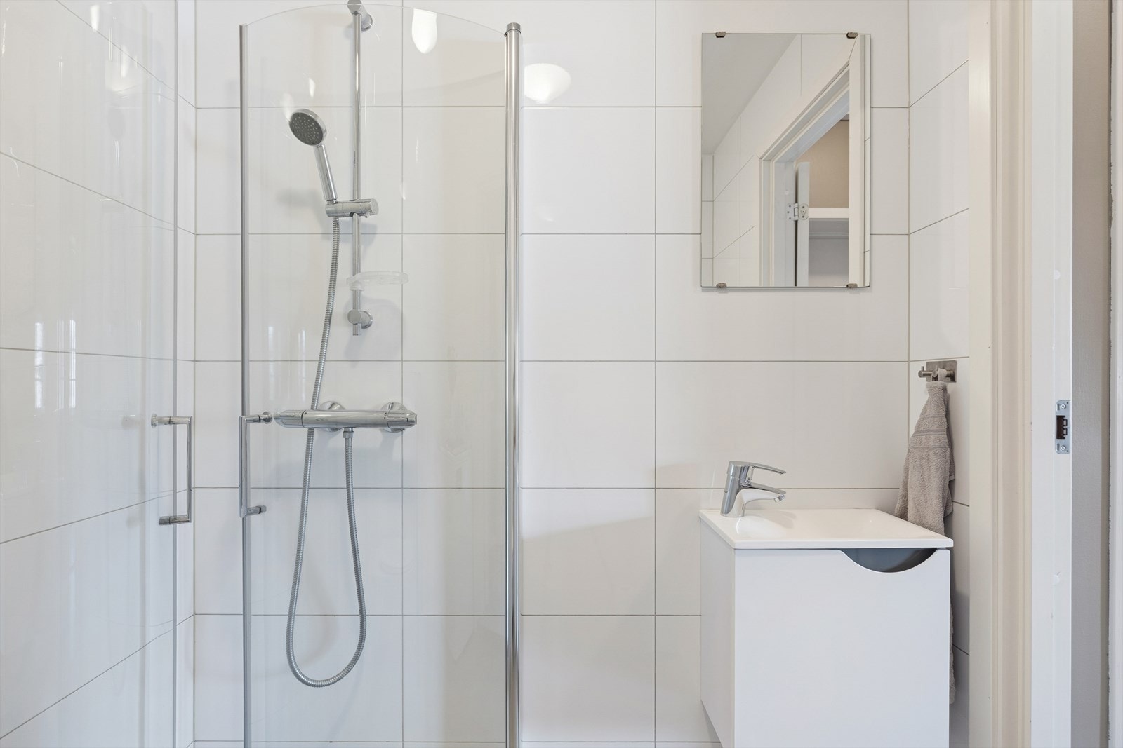 Rommet har innredning med nedfelt servant, veggmontert toalett og dusjvegger/hjørne. Elektrisk styrt vifte. Et godt sted å starte dagen! Galleribilde