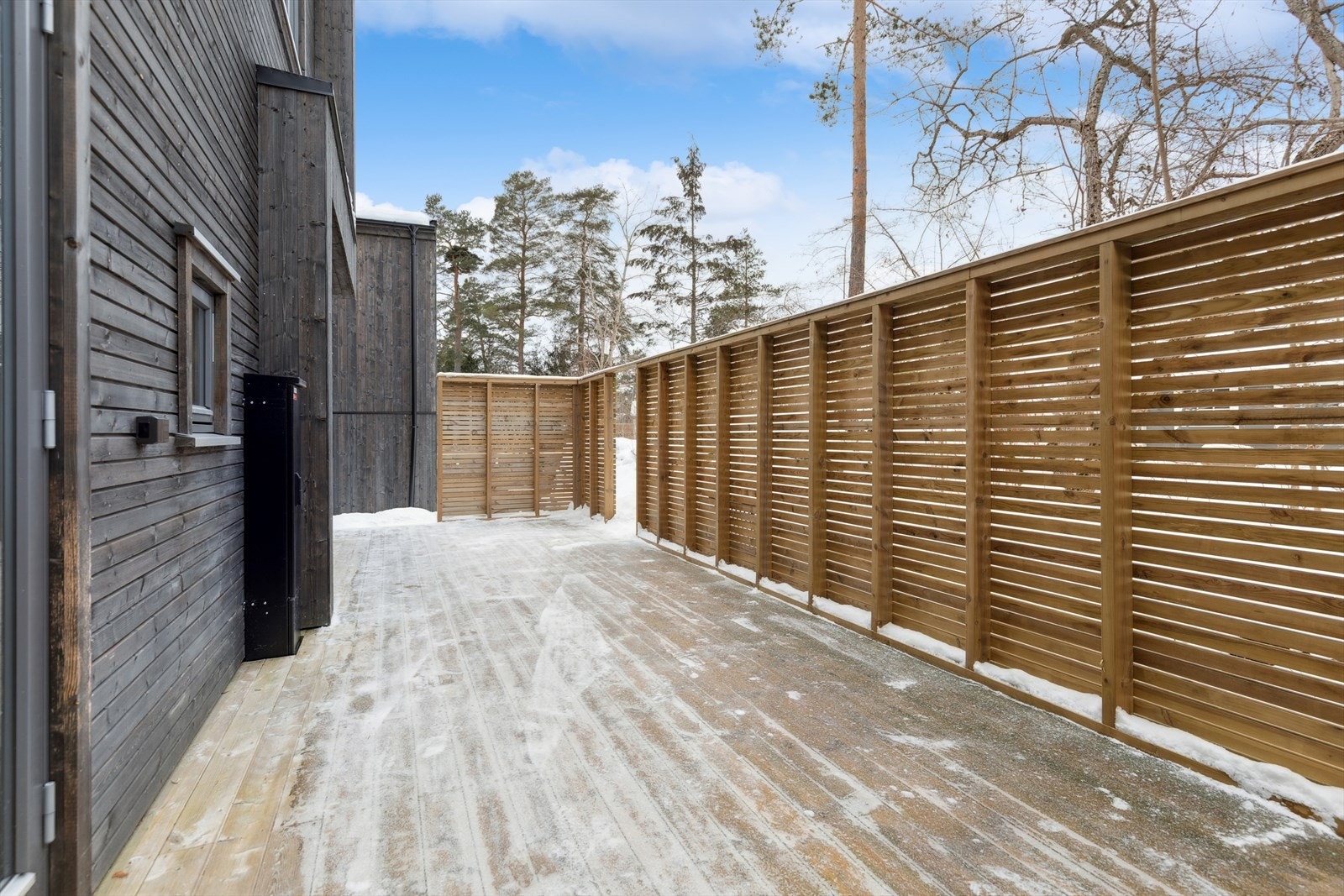 Her kan man gå rett ut fra stuen til en stor skjermet terrasse. Galleribilde
