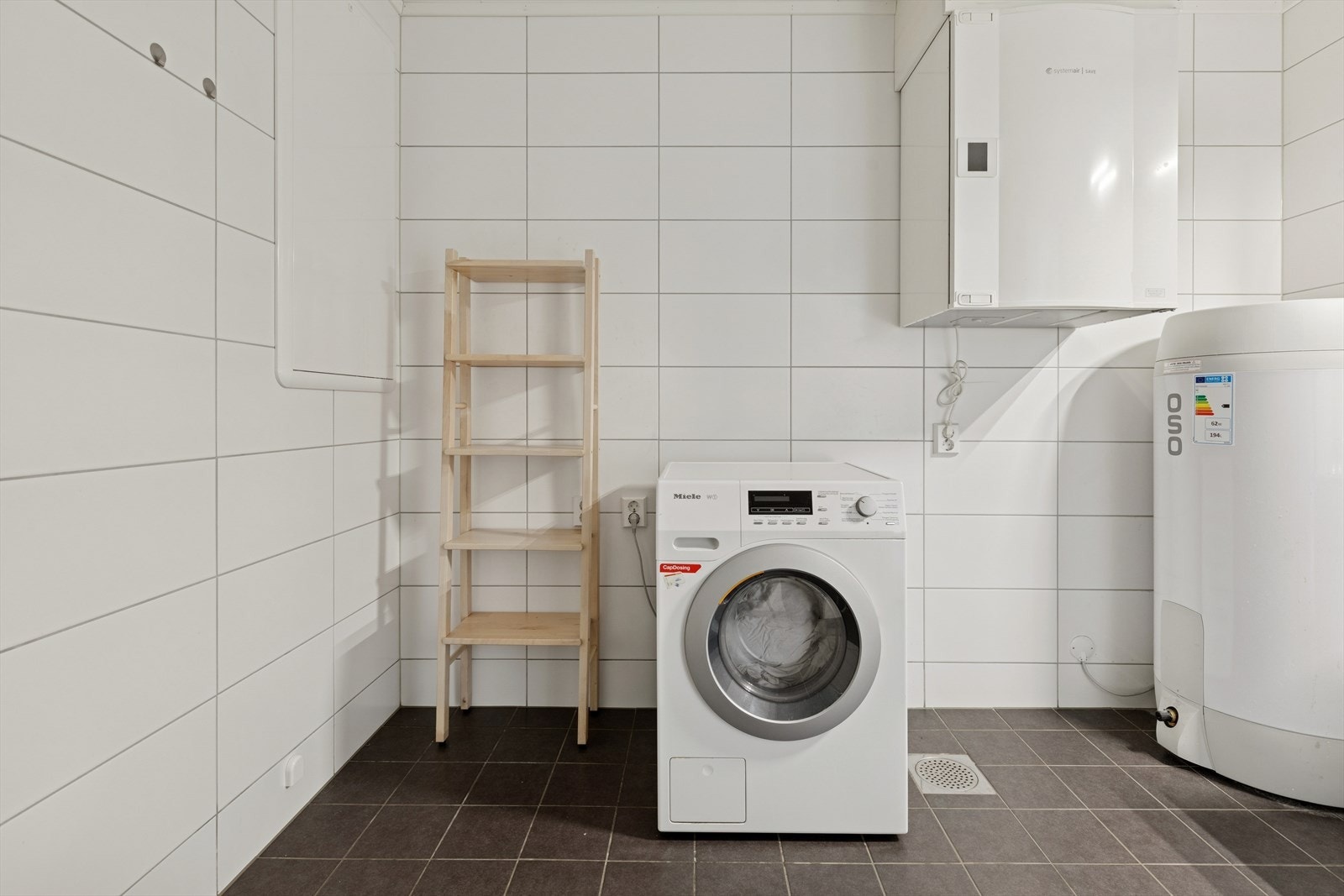 Her er det plass til vaskemaskin og annen innredning. Varmtvannsbereder og ventilasjonsanlegg er også sentrert her. Galleribilde