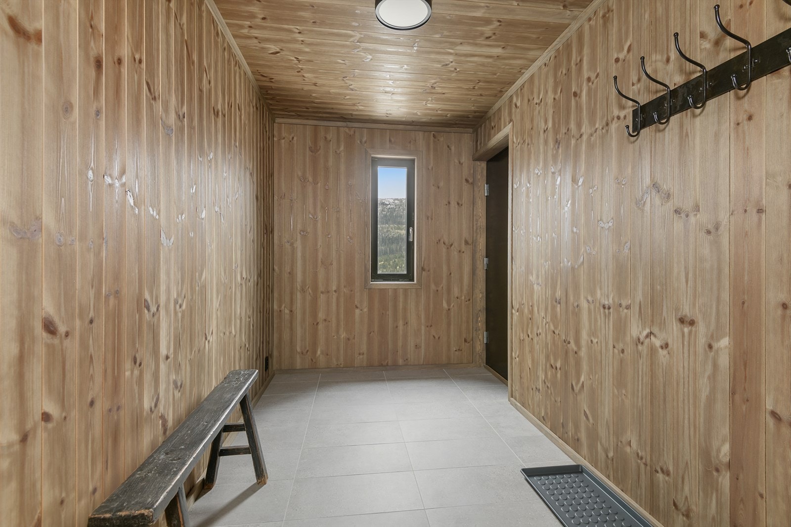 Romslig bod med flislagt gulv og god plass til å henge fra seg yttertøy og utstyr. Galleribilde