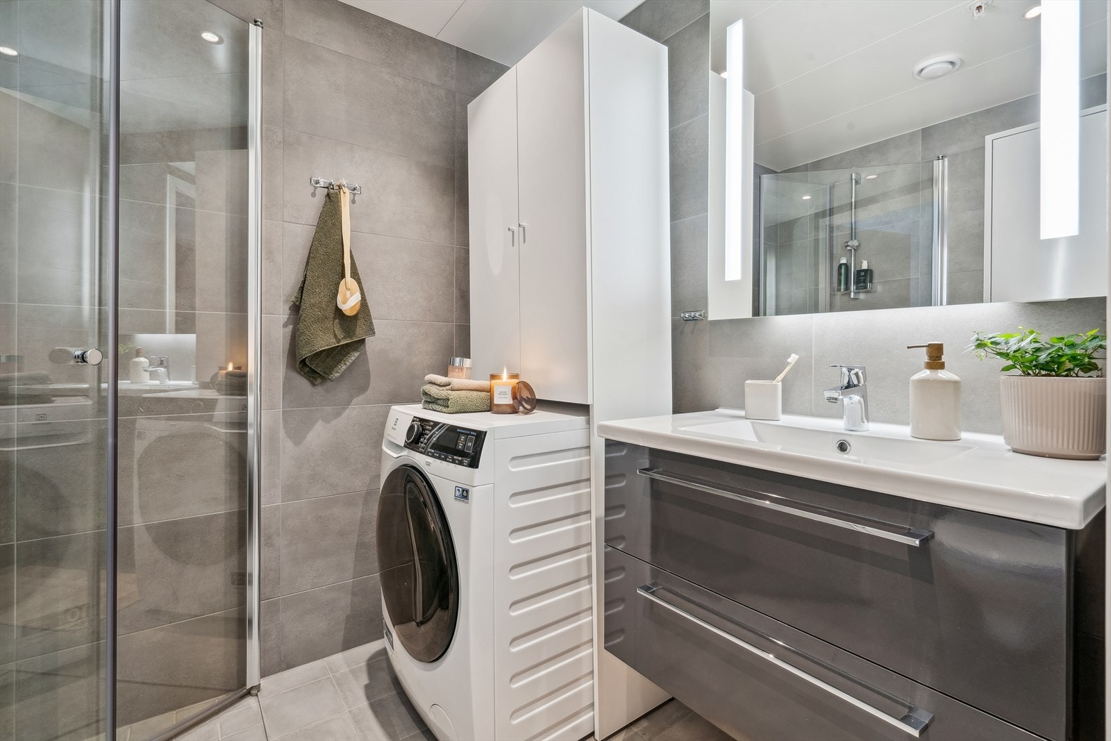 Dagene får en god start på et helfliset bad med moderne finish, utstyrt med downlights og opplegg for vaskemaskin. Galleribilde