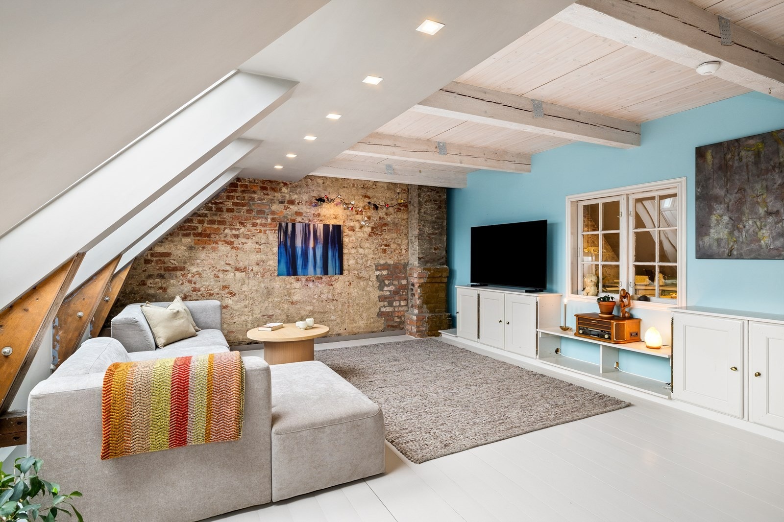 Herlig stue med et kreativt vindu mot kjøkkenet - en smart løsning som gir ekstra lys og skaper en naturlig forbindelse mellom rommene. Galleribilde