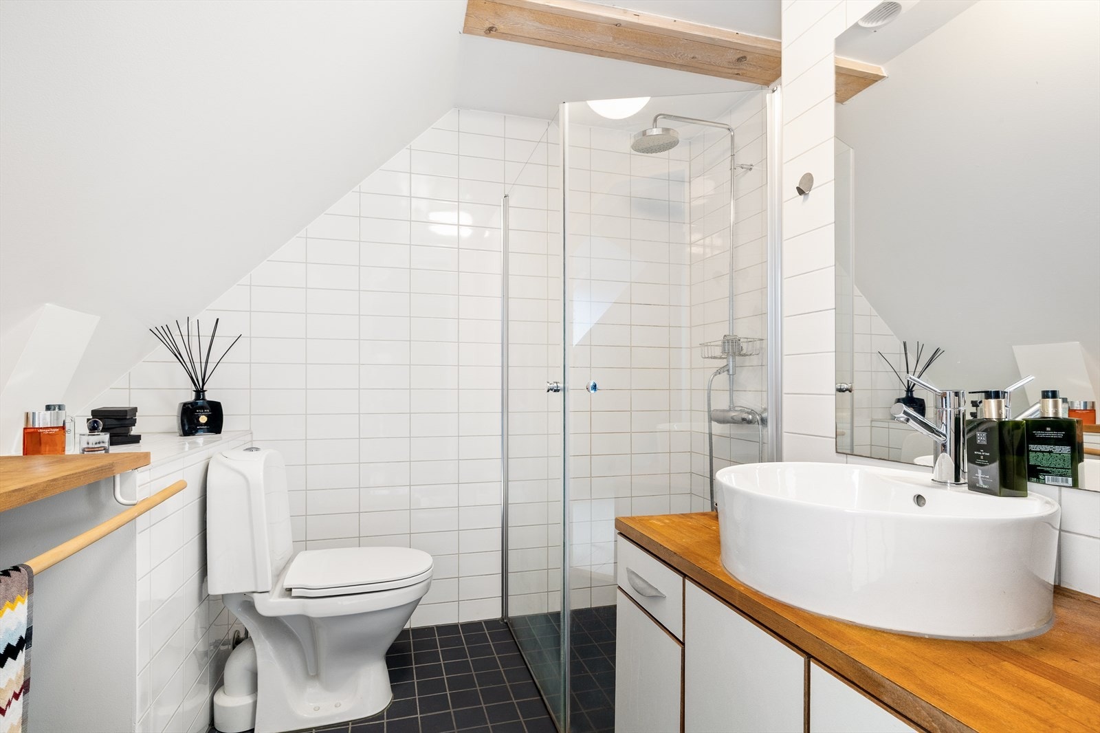 Badet har en klassisk stil med varme i gulvet - og er utstyrt med WC, dusjnisje og en elegant servant med innredning. Et rom som gir både komfort og tidløs sjarm. Galleribilde