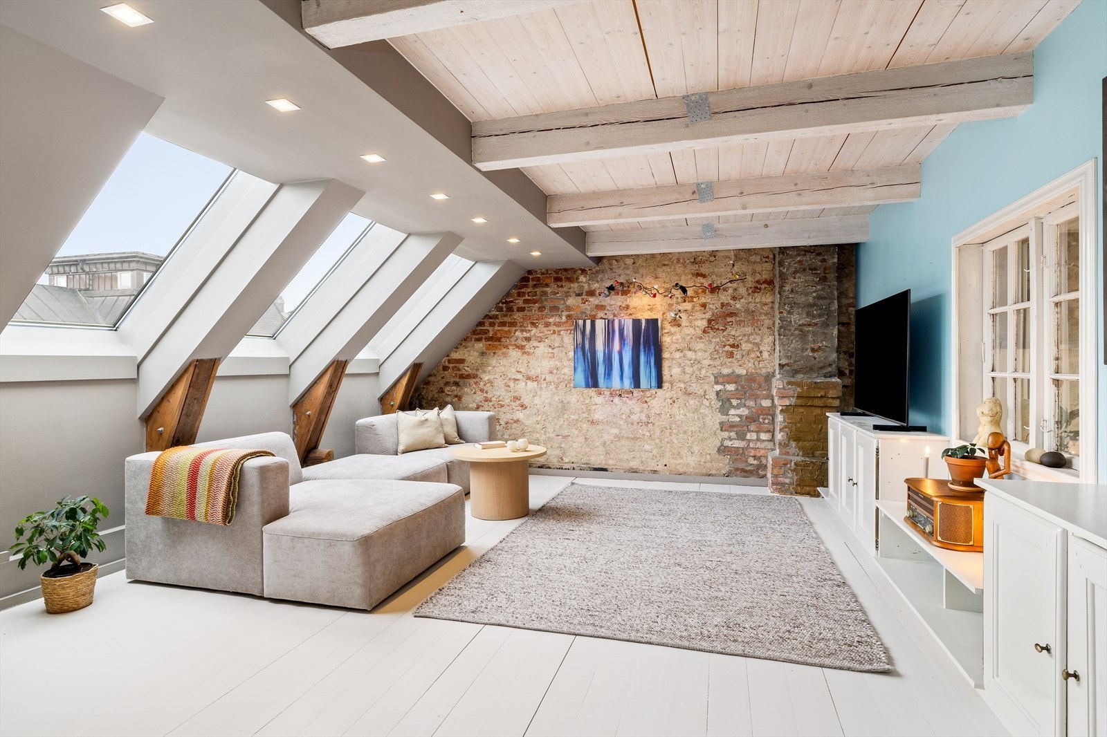 Her får du en fantastisk leilighet med sjarm og karakter! Den romslige stuen byr på spennende detaljer som eksponert teglsteinsvegg og synlige dragere. Dette kombineres med moderne innslag og stilrene downlights, som skaper innbydende atmosfære. Galleribilde