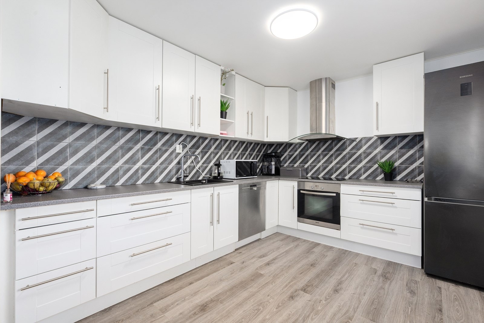 Kjøkkenet har integrert induksjonstopp og stekeovn, og det er avsatt plass til frittstående oppvaskmaskin og kjøl/fryseskap. Over kokesonen er det en stilig ventilator med avtrekk ut. Galleribilde