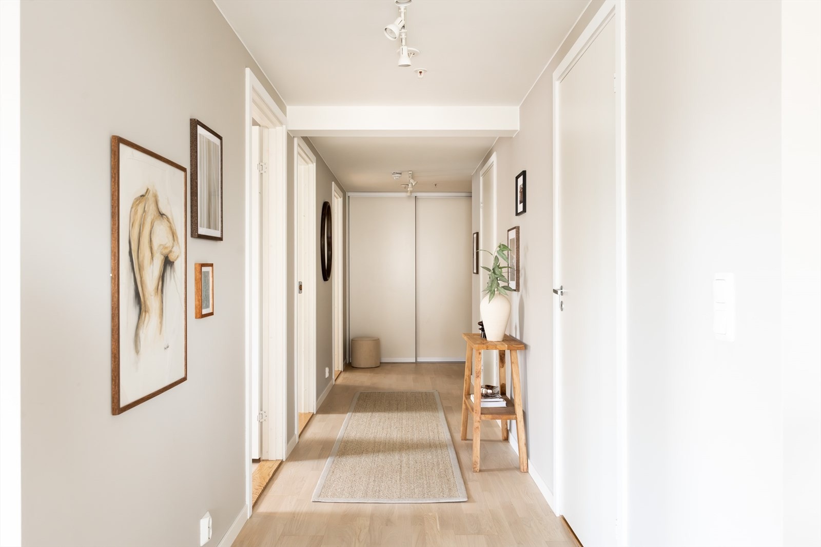 Lun og romslig soveromsgang med stor skyvedørsgarderobe som gir rikelig med oppbevaringsplass. Galleribilde