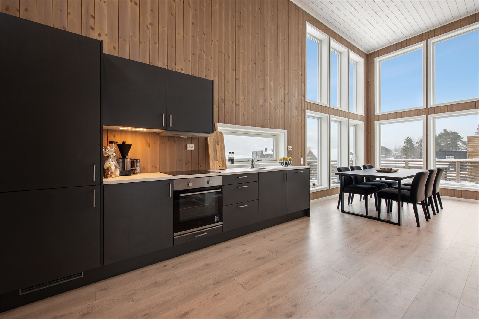 Moderne kjøkkeninnrednning med slette fronter og integrerte hvitevarer for en sømløs finish Galleribilde