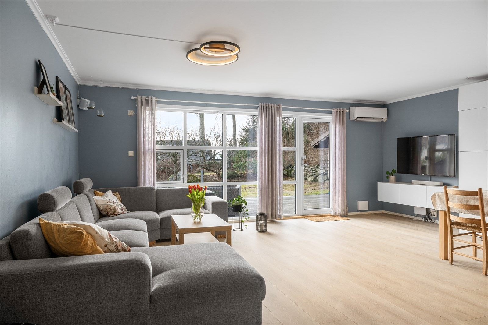 En romslig stue med gode møbleringsmuligheter, og med direkte utgang til hagen. Store vindusflater sørger for rikelig med dagslys og en behagelig romfølelse Galleribilde