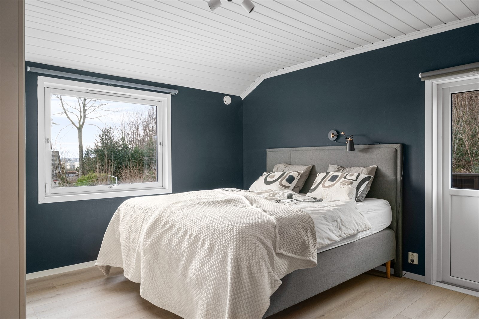 Romslig hovedsoverom med harmoniske farger, garderobeløsning og plass til nattbord. Galleribilde