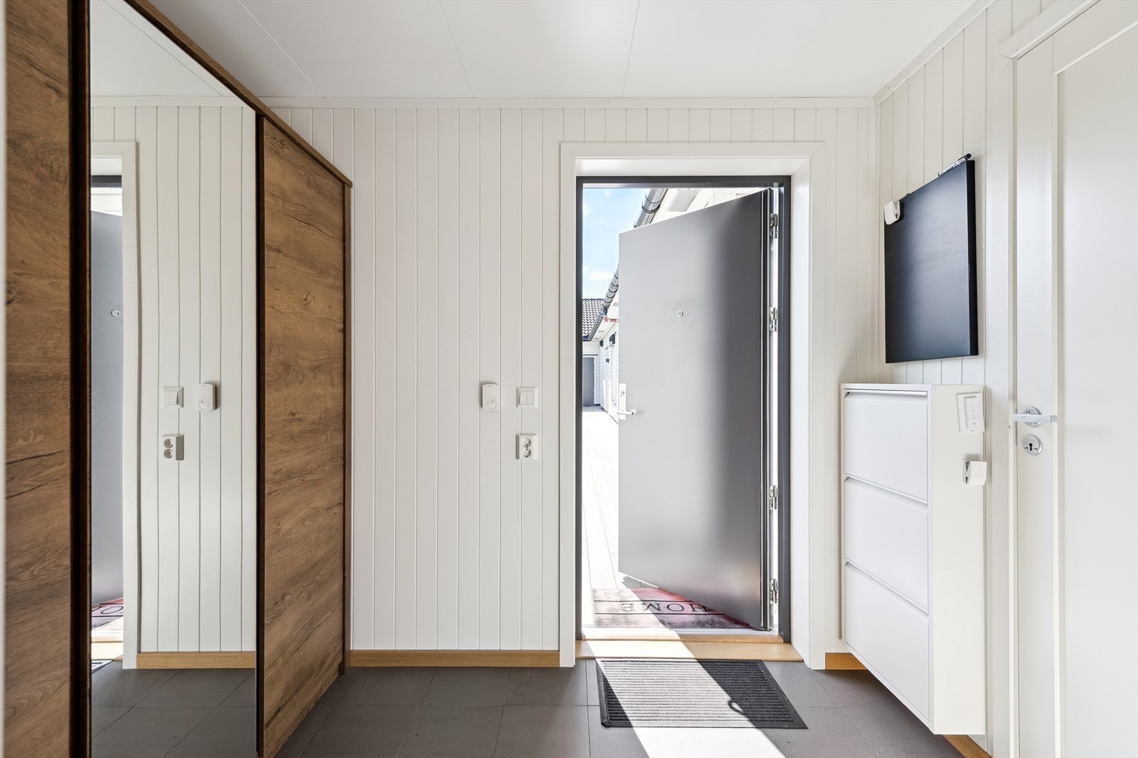 Entréen har slitesterke fliser og vannbåren gulvvarme, som gir en behagelig velkomst. Galleribilde