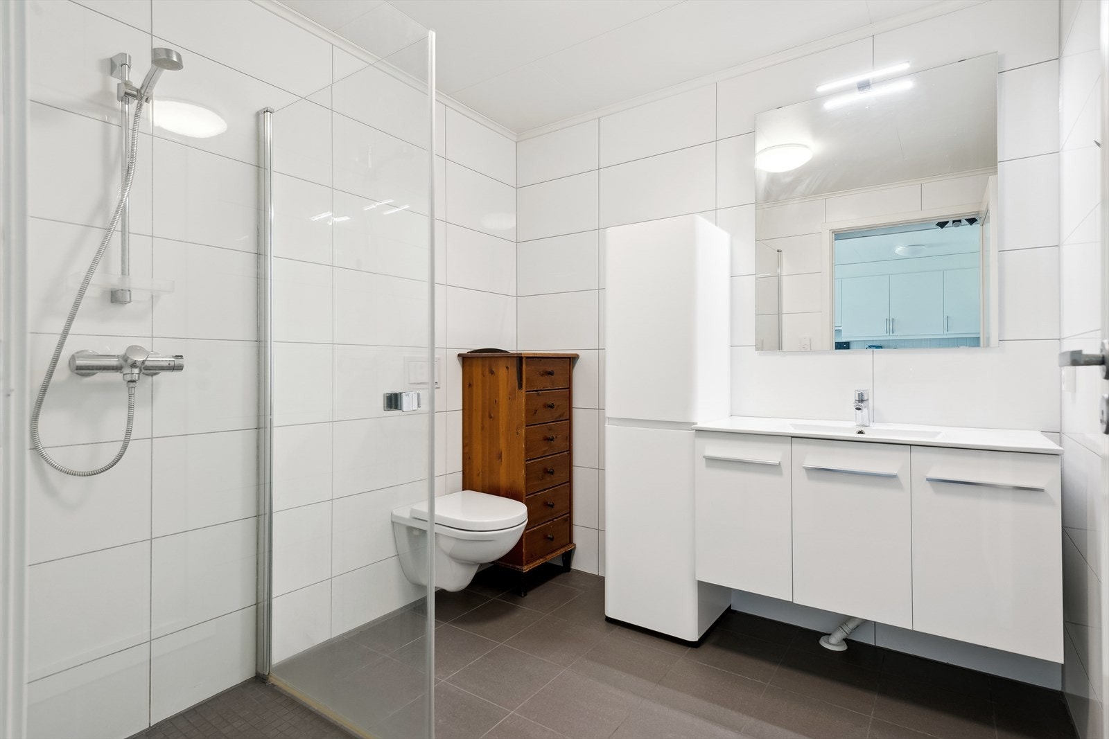 Rommet er utstyrt med vegghengt toalett og en dusjnisje med innfellbare skjermdører i herdet glass. Galleribilde