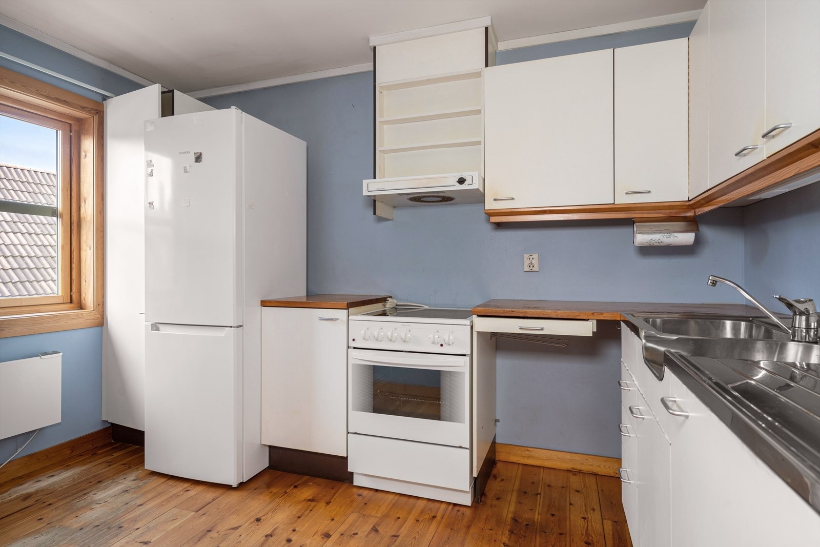 Kjøkken med eldre innredning og frittstående hvitevarer (medfølger) Galleribilde