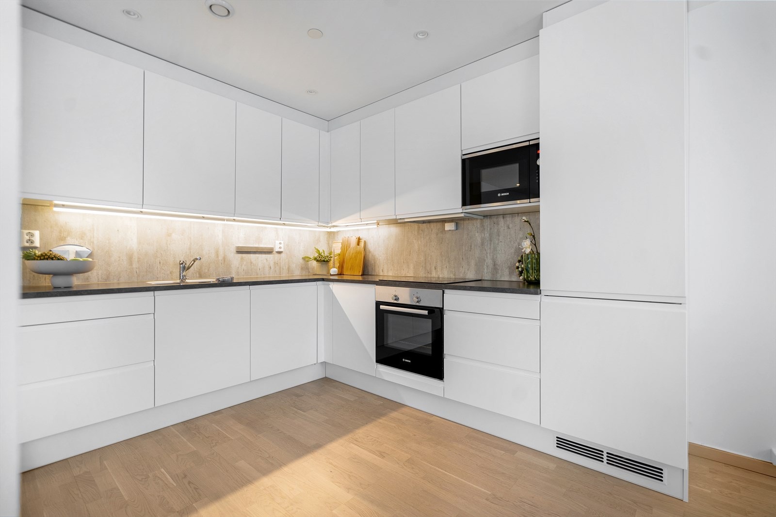 Kjøkkenet har lyse, slette fronter med benkeplate av laminat. Galleribilde