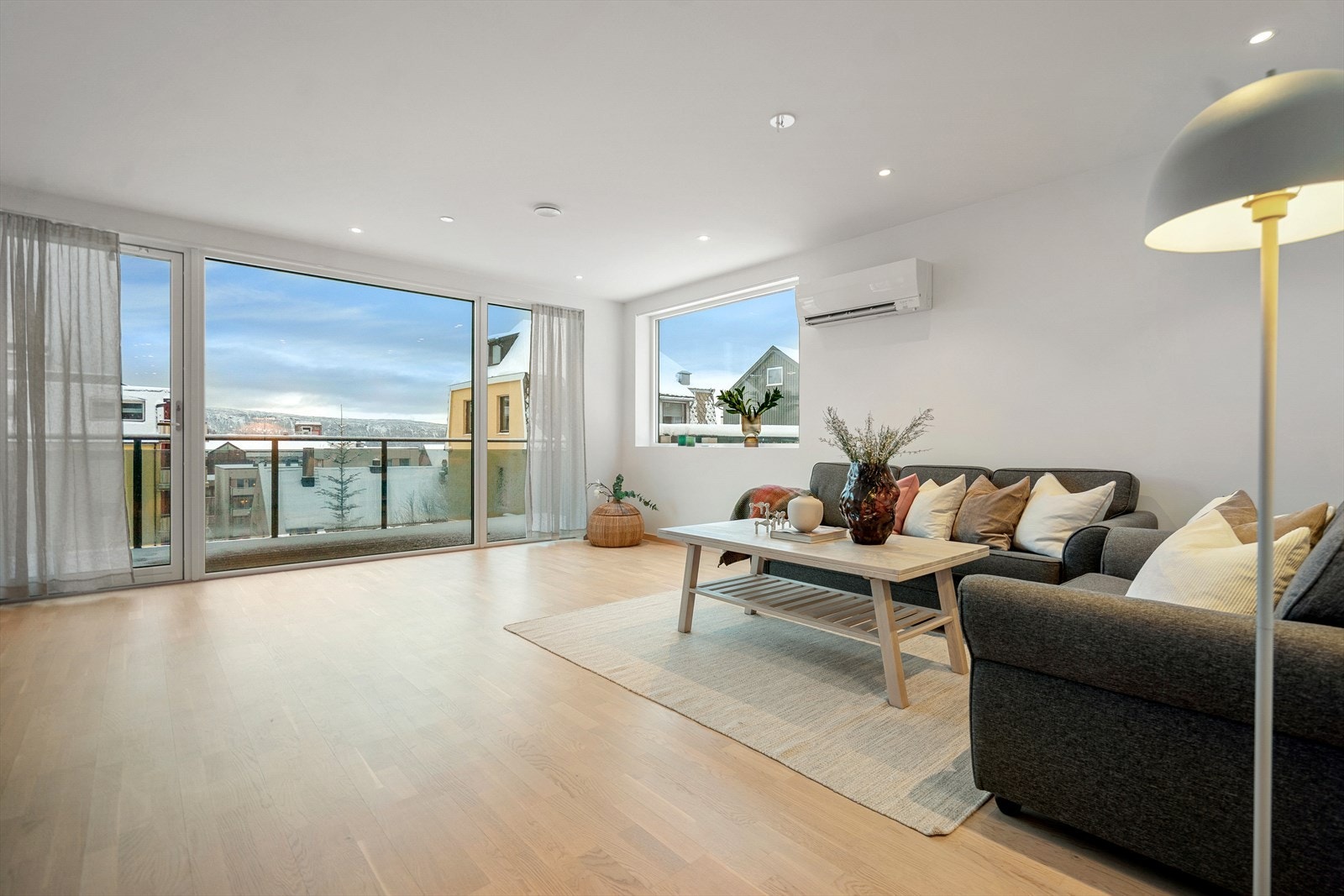 Stue med store vindusflater gir rommet rikelig med lysinnslipp. Galleribilde