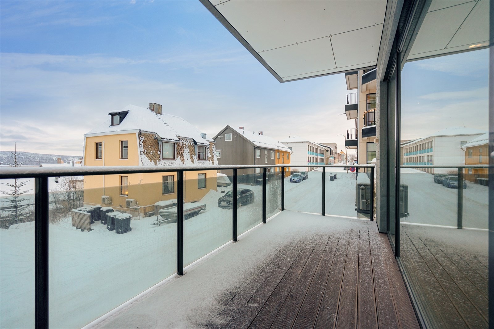 Balkongdekket er av trevirke og rekkverk i stål og glass Galleribilde