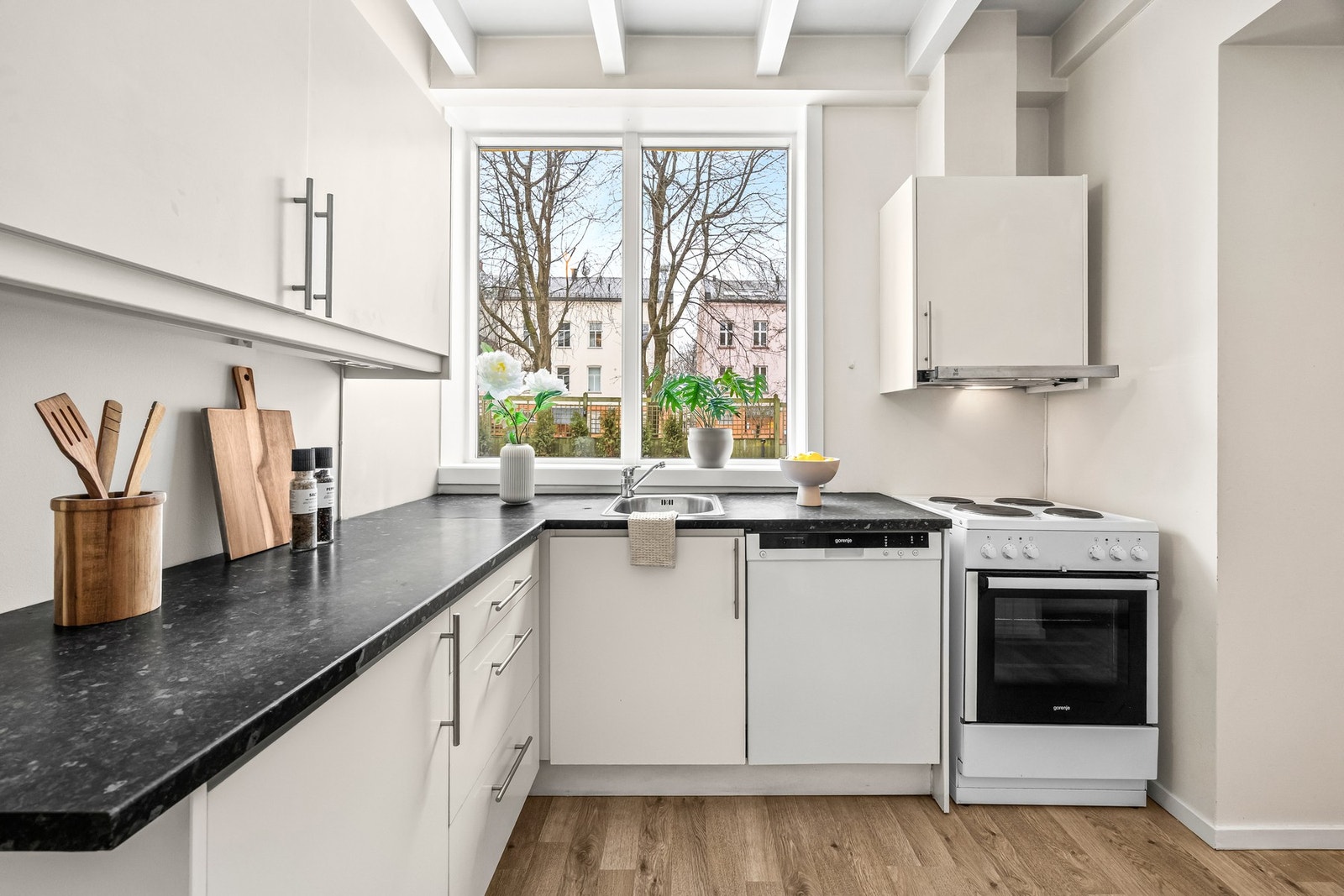 Kjøkkeninnredningen er L-formet og har hvite skapflater. Galleribilde