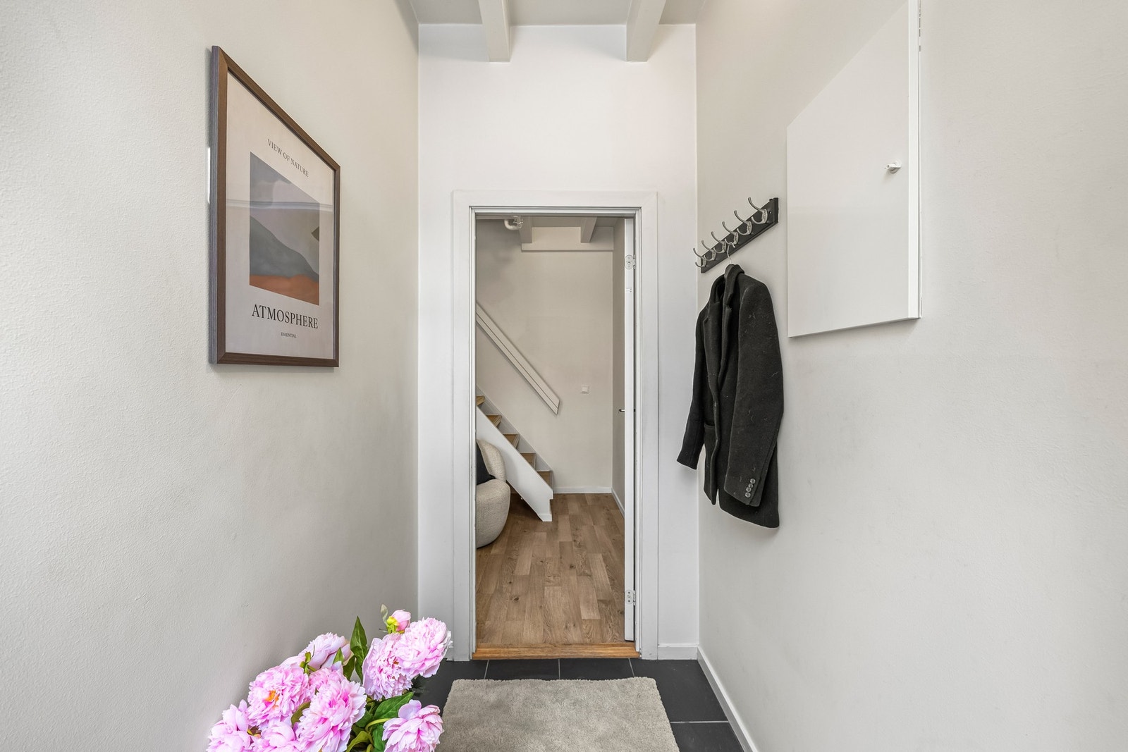 Inngangspartiet er flislagt. Sikringsskap på veggen og vegghengt knagger til ytterjakker. Galleribilde