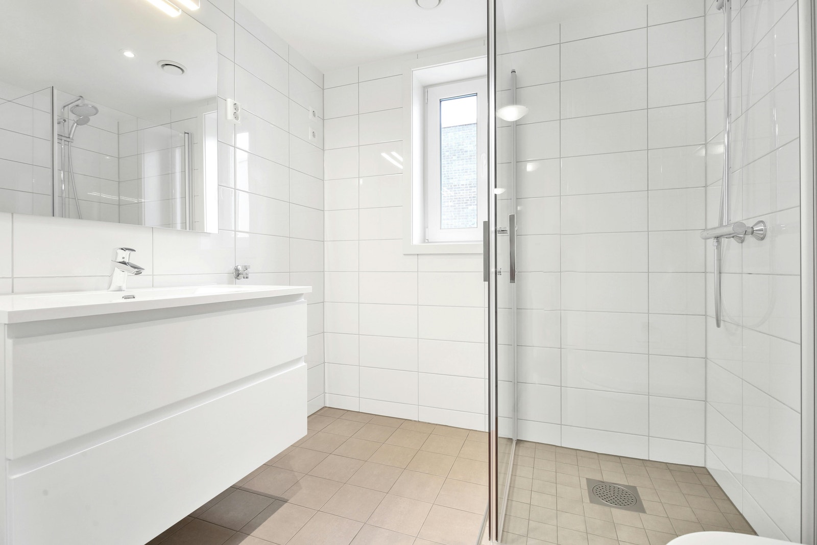 Lekkert flislagt bad med opplegg for vaskemaskin Galleribilde