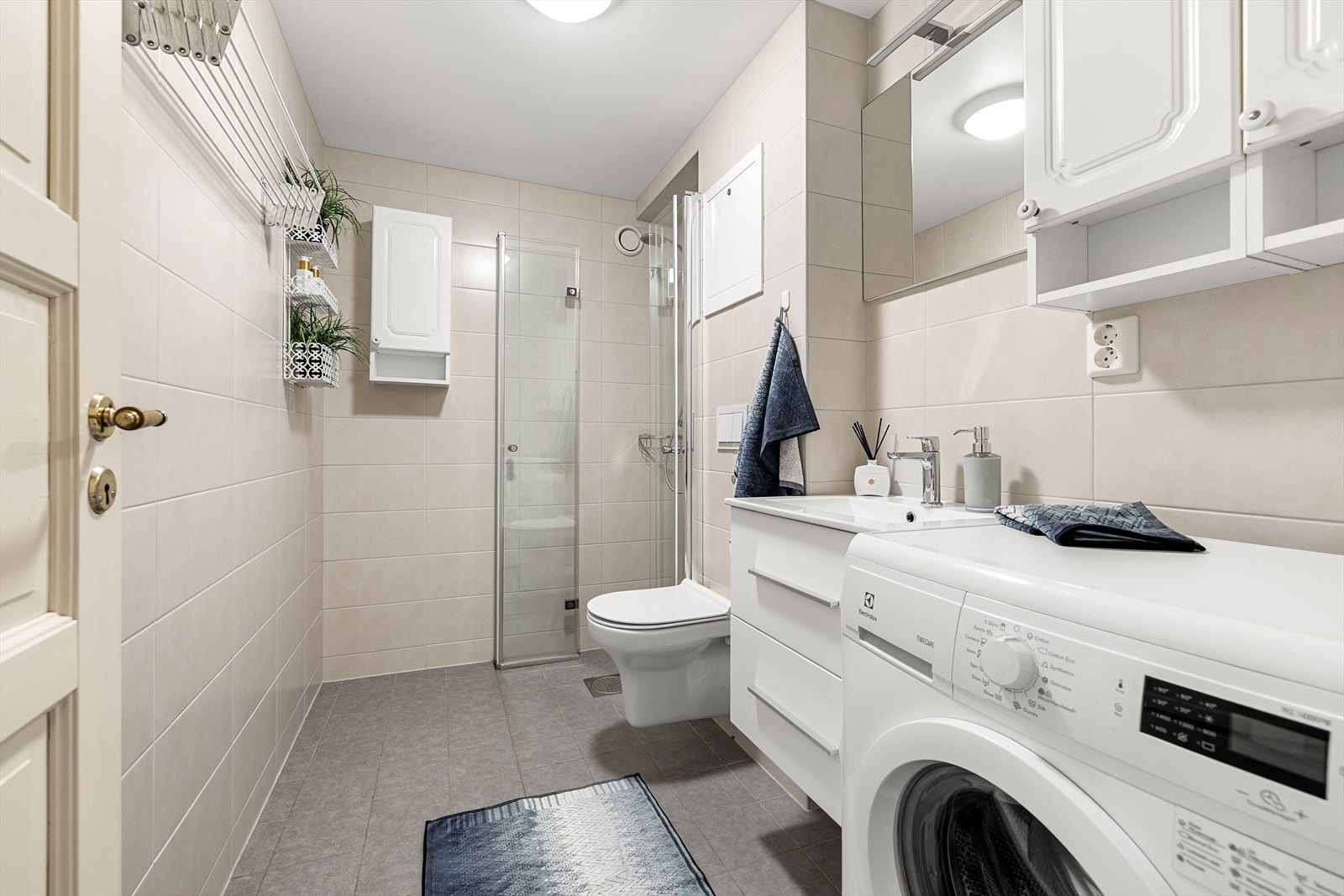 Lyst og moderne bad, flislagt og oppusset i 2023. Rommet er godt utnyttet med plassbesparende løsninger som vegghengt servantskap, speil med tilhørende belysning, dusjhjørne med glassvegger og vegghengt toalett. Galleribilde