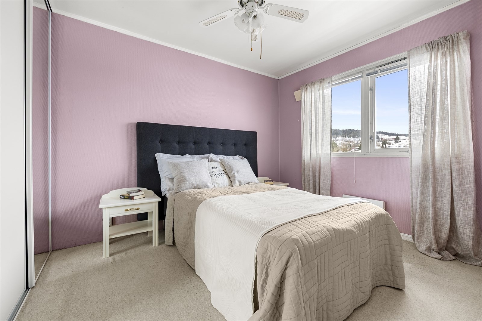 Leiligheten har et lyst og romslig soverom med malte flater og vegg til vegg-teppe. Rommet gir god plass til dobbeltseng, nattbord og garderobeløsninger. Galleribilde