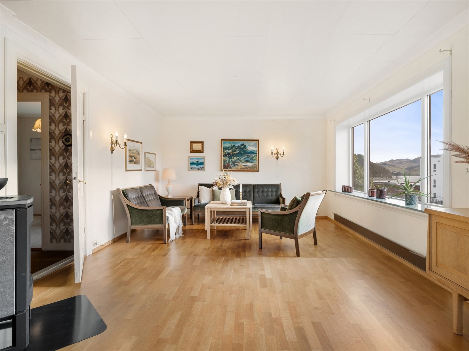 Romslig stue med plass til flere sittegrupper. Galleribilde