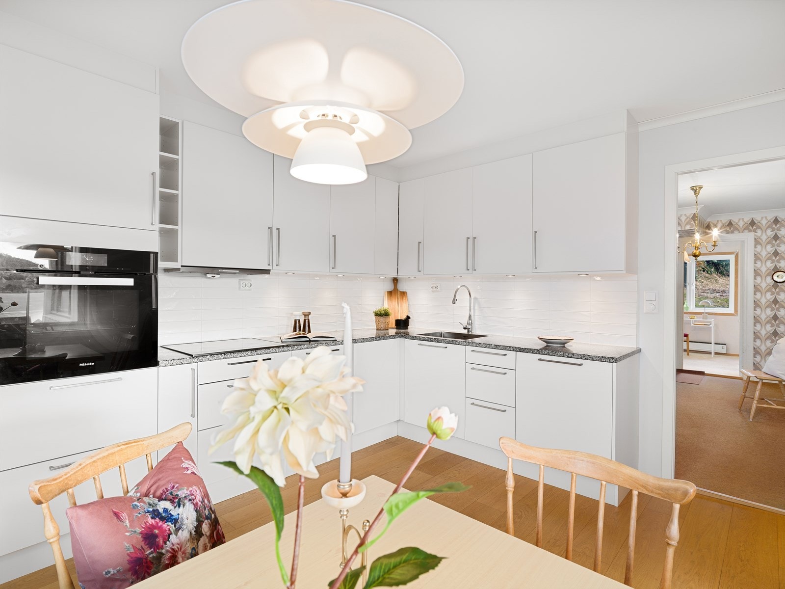 Fliser og spotter over kjøkkenbenk. Integrerte hvitevarer. Galleribilde