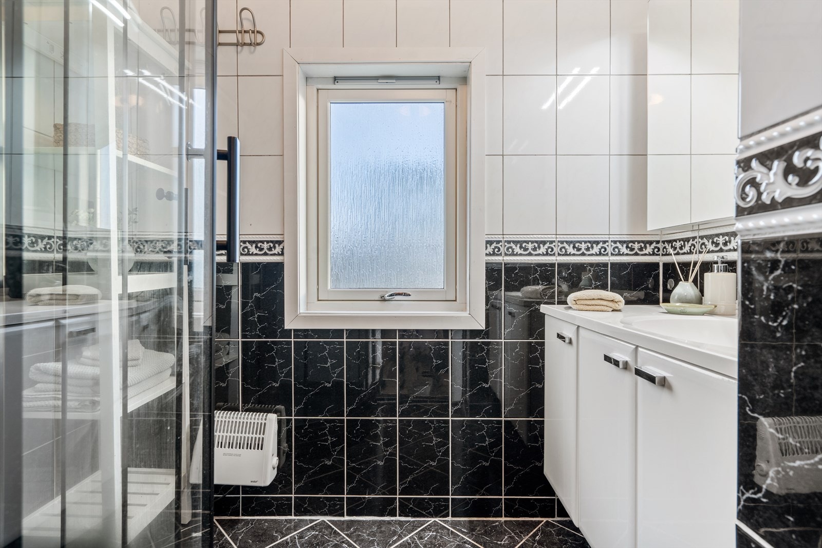 Dusjrom/bad med flislagte vegger og gulv. Rommet har innredning med nedfelt servant og dusjkabinett. Det er naturlig ventilering. Galleribilde