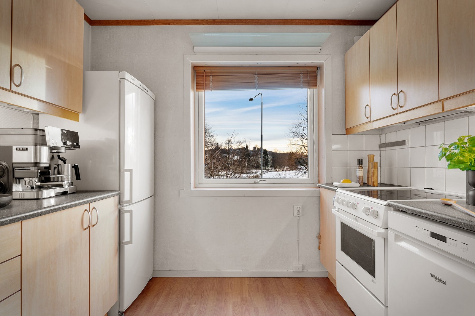 Kjøkkeninnredning med glatte fronter og laminat benkeplate. Fra kjøkken har man også utsikt mot tveitevannet. Galleribilde