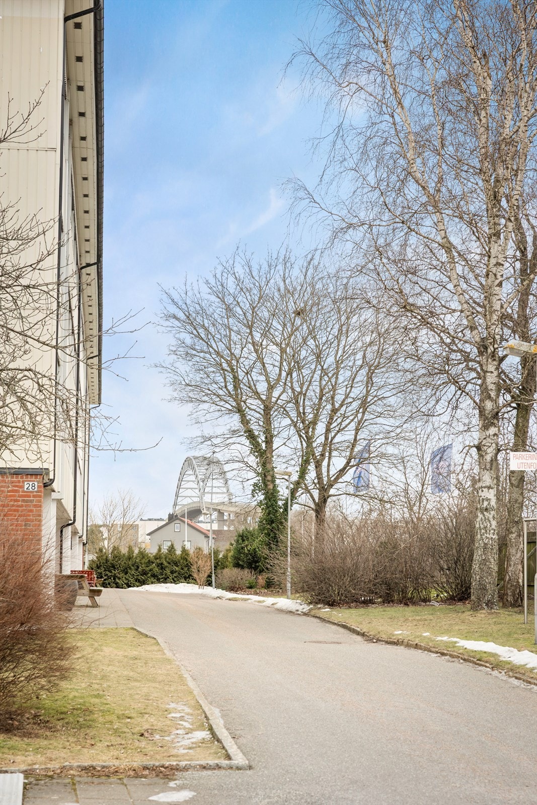 Eiendommen har adkomst via offentlig vei, omgitt av et velstelt fellesareal med busker og plen. Galleribilde