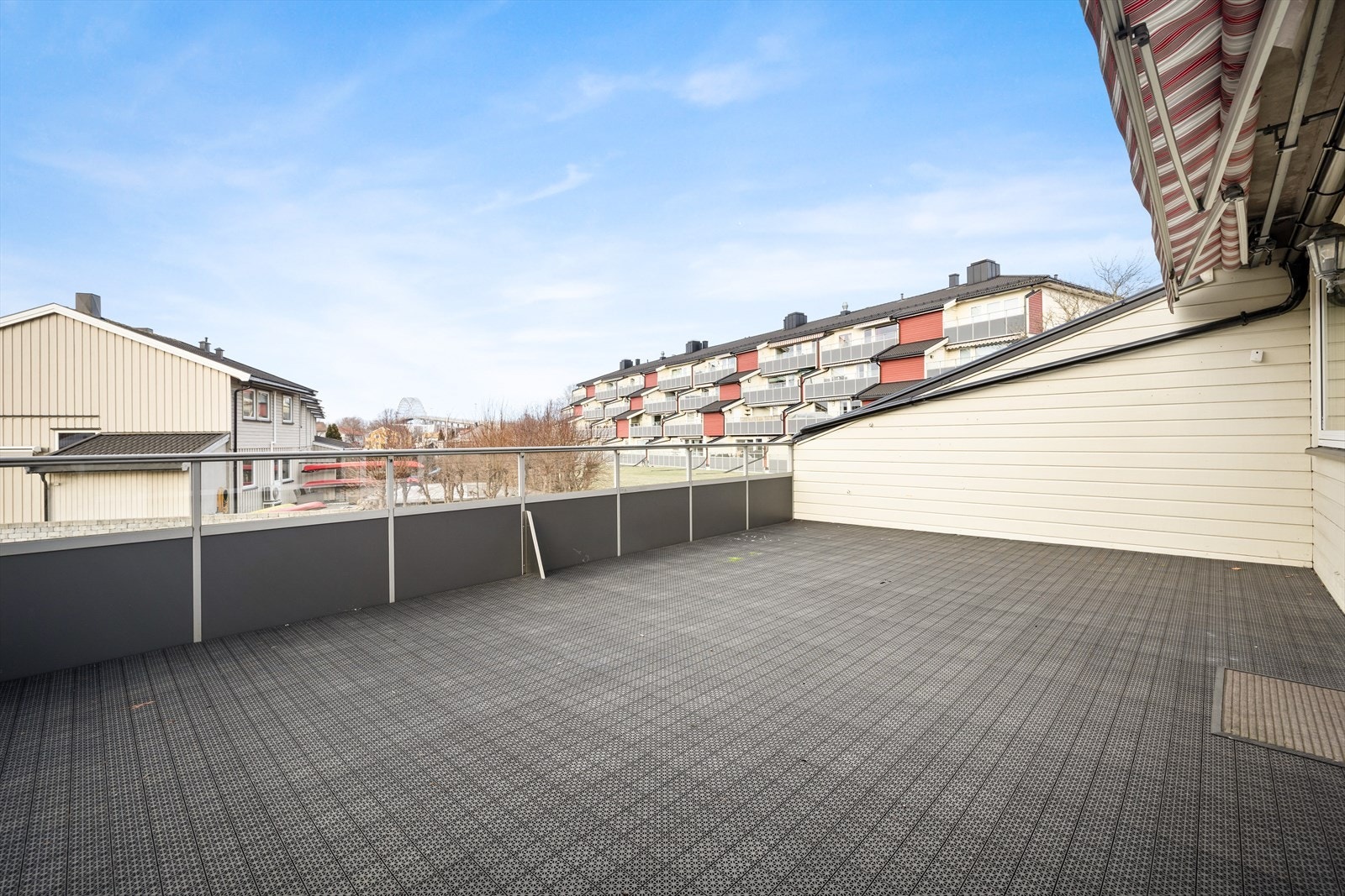 Terrassen har betongdekke med PVC-fliser og aluminiumsrekkverk med glassfelt. Galleribilde