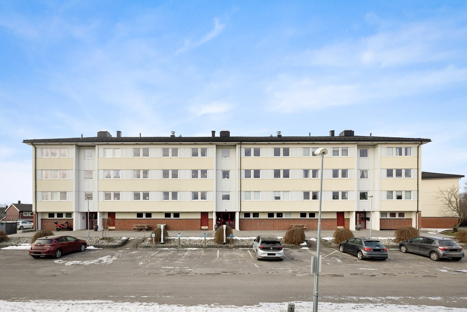 Bygningen har en stor parkeringsplass foran, med flere tilgjengelige parkeringsplasser for beboere. Galleribilde