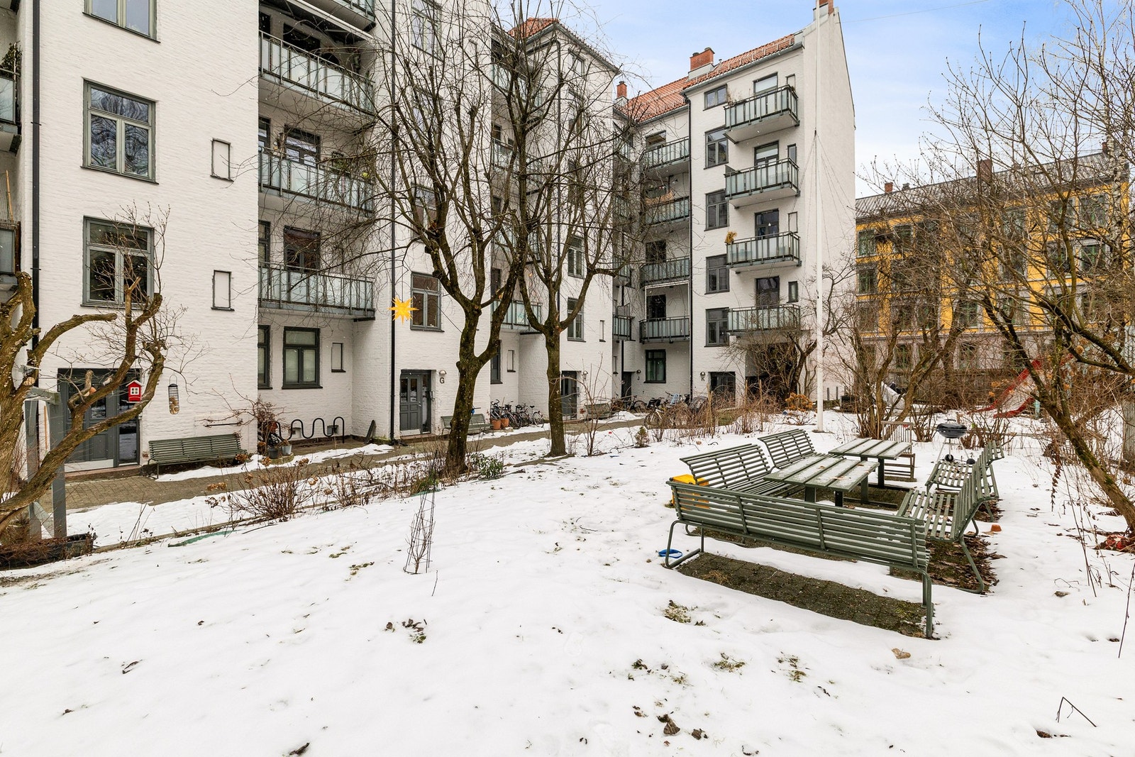 Bakgården er velstelte grøntarealer, samt at det er satt ut sittebenker, bord og felles kullgrill. Galleribilde