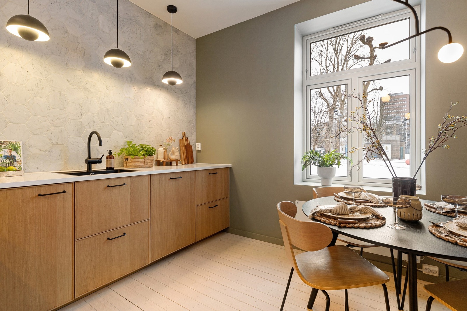 Innredningen har glatte fronter fra IKEA i Ekestad-serien, som gir et varmt og tidløst uttrykk i kombinasjon med den høyglansede, hvite laminatbenkeplaten. Galleribilde