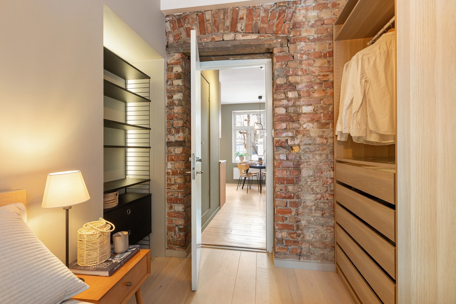 Veggen ut mot kjøkkenet har synlig teglstein som tilfører rommet karakter og knytter det naturlig sammen med boligens gjennomgående, historiske preg. Galleribilde