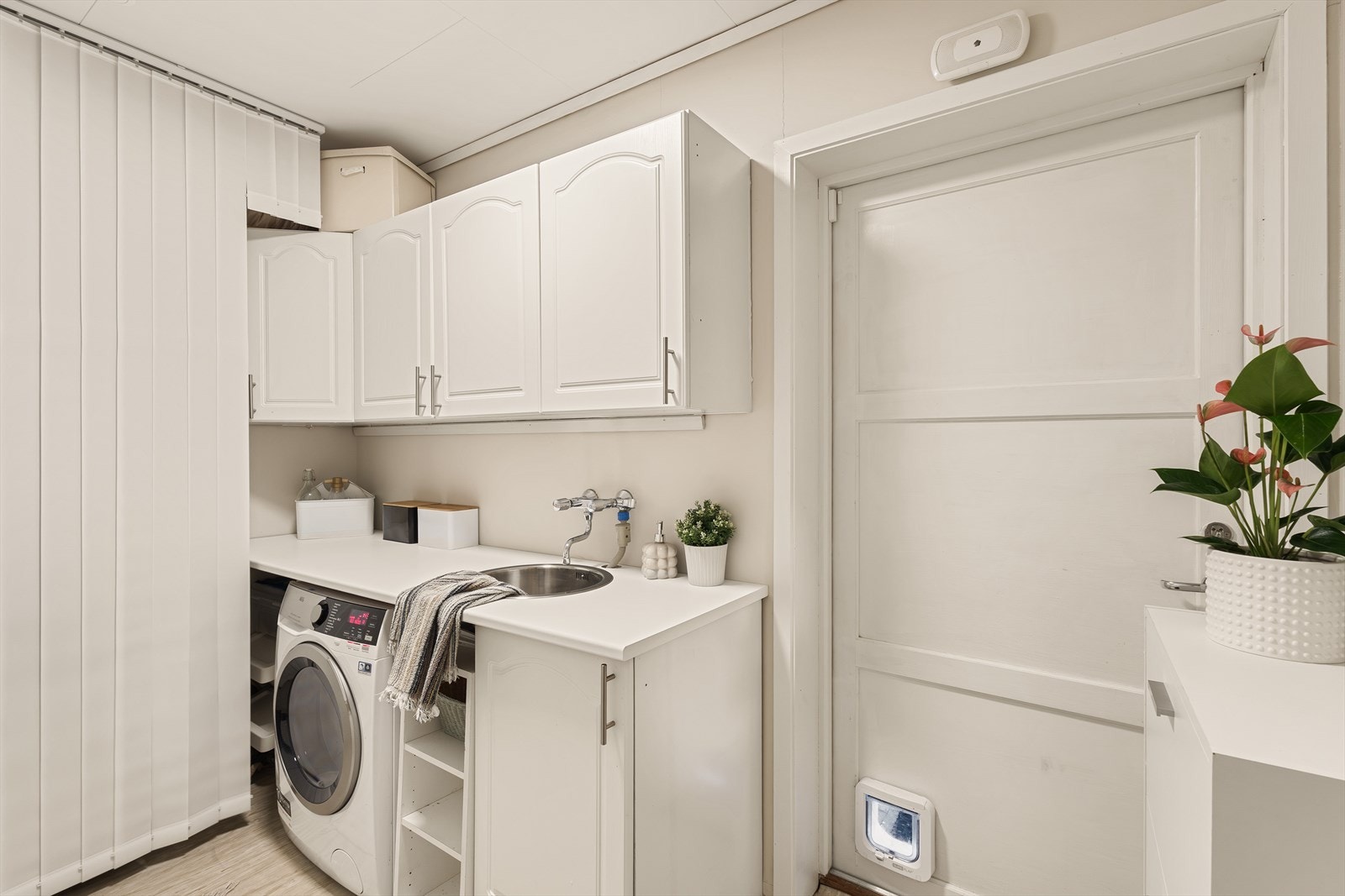 Praktisk vaskerom med opplegg for vaskemaskin. Fra vaskerommet er det dør ut til uteplass. Galleribilde