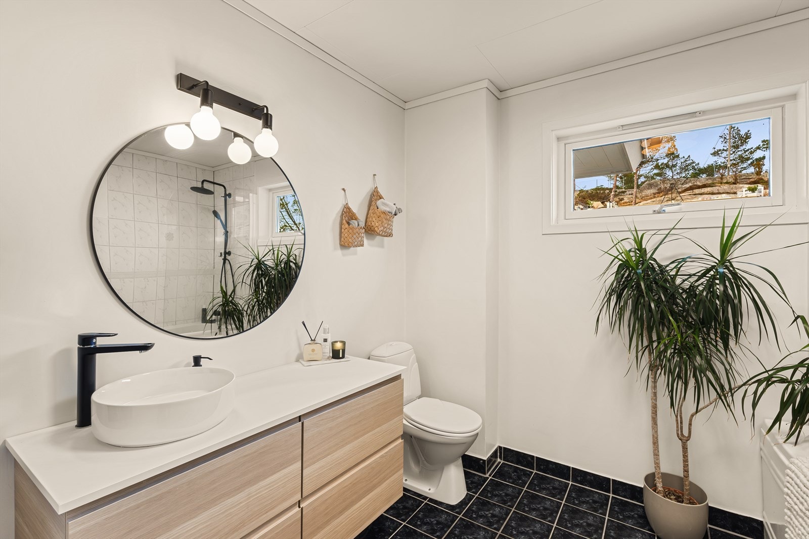 Baderom innredet med servant møblement, badekar og toalett. Galleribilde