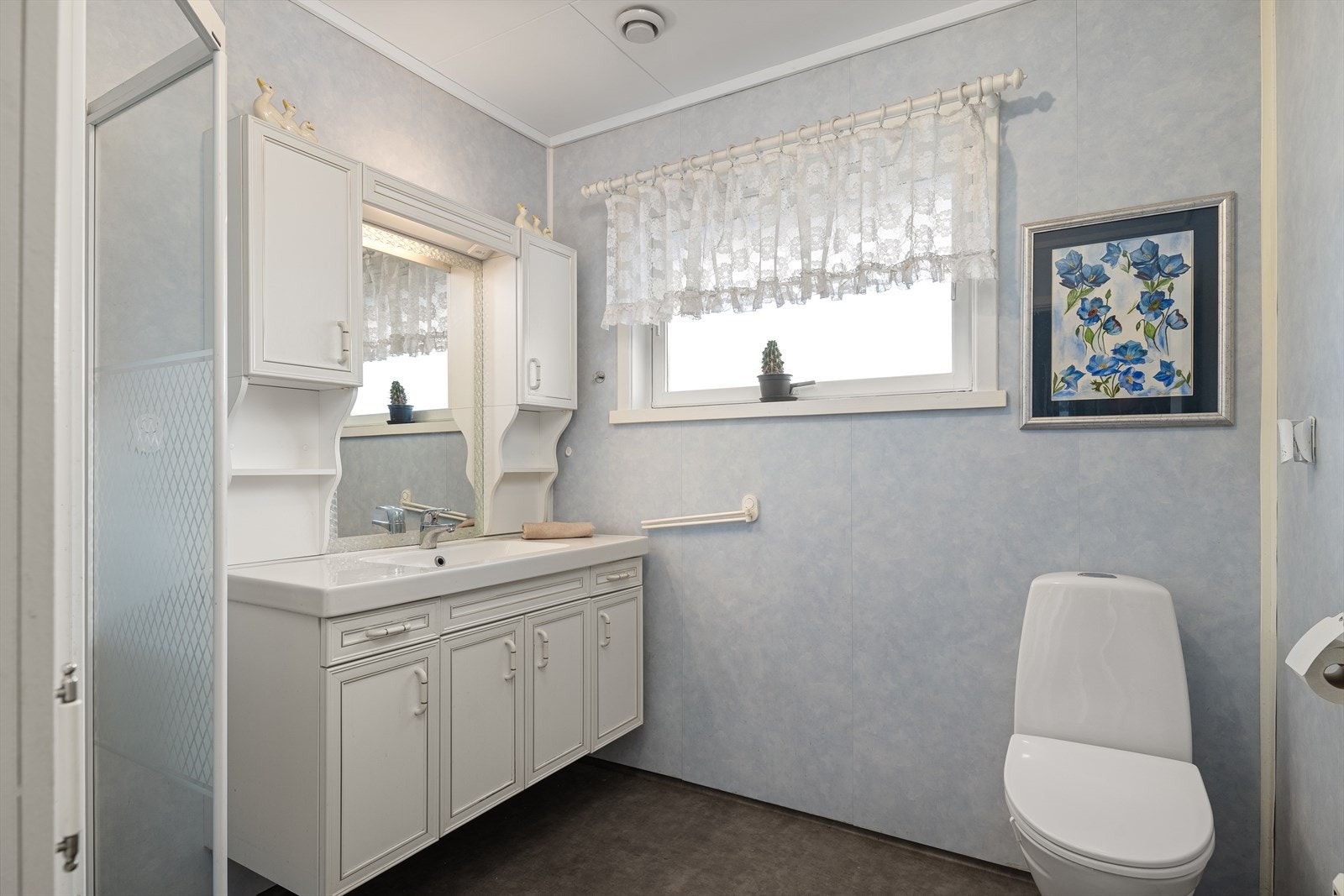 Badet inneholder baderomsinnredning, dusj og toalett Galleribilde