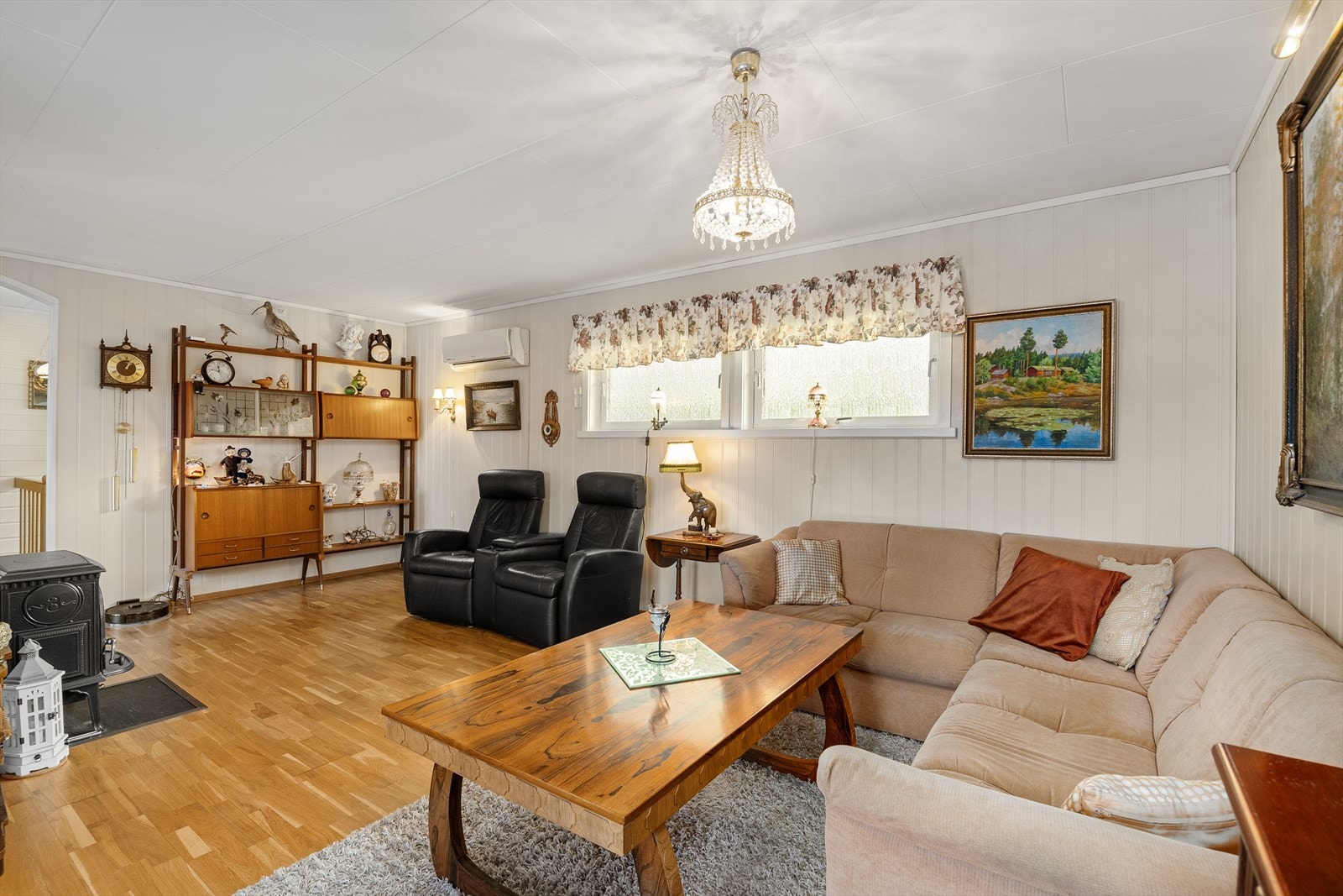 Stuen er lys med både installert varmepumpe og vedovn Galleribilde