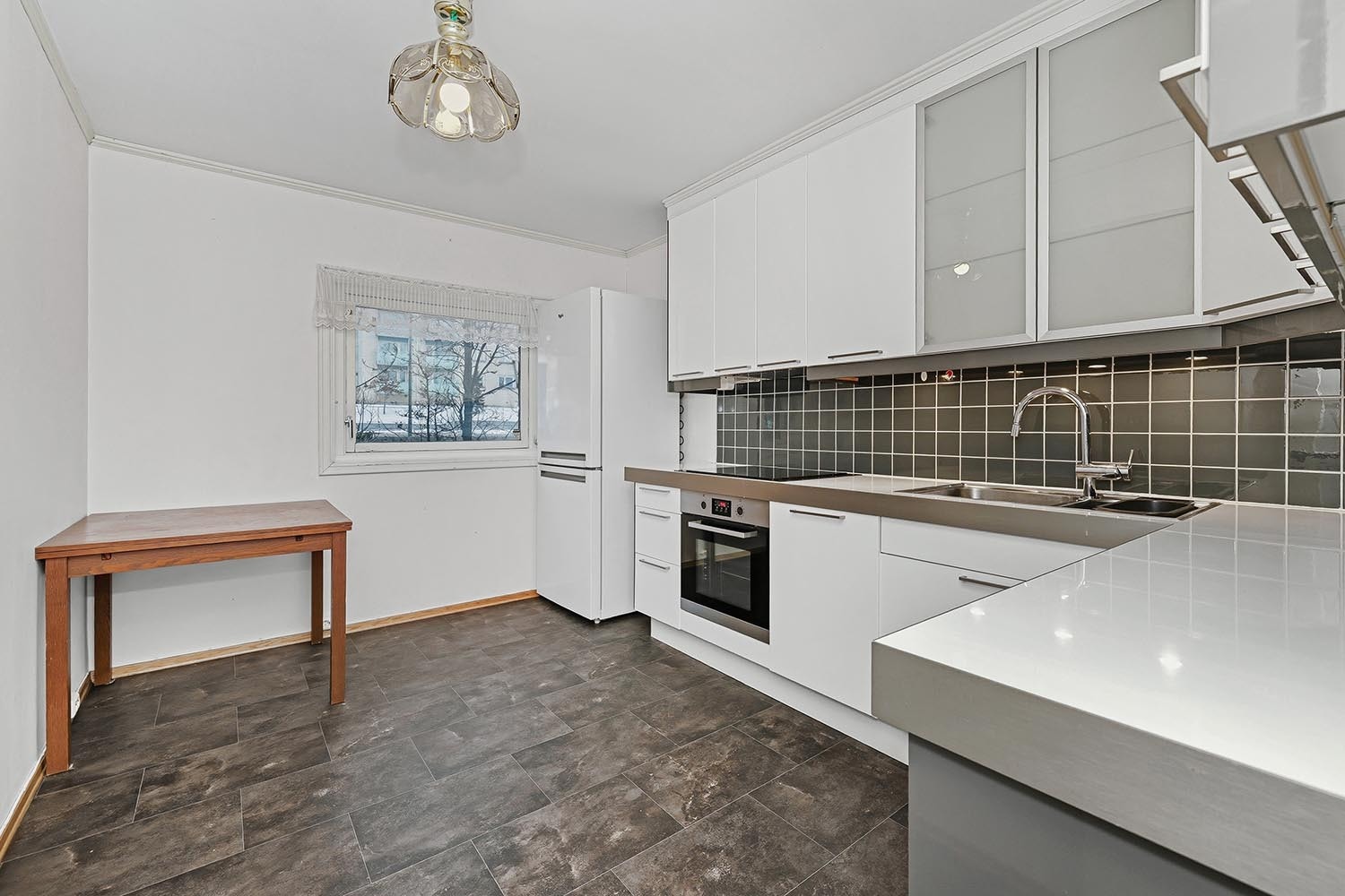 Stekeovn, platetopp, kombiskap, oppvaskmaskin og spisebord. Galleribilde