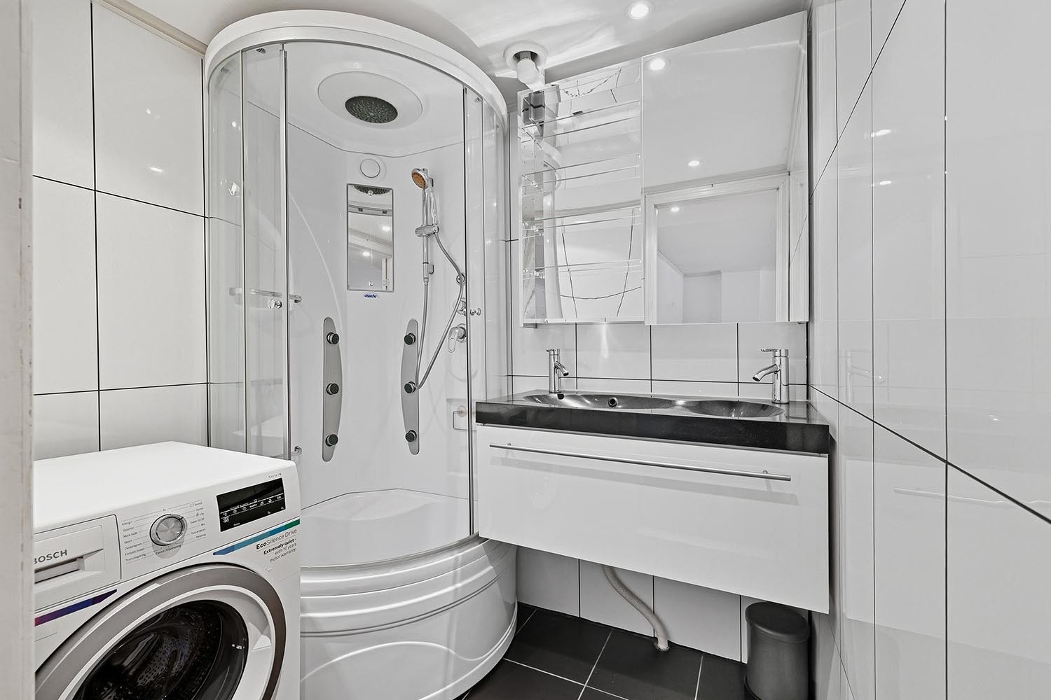 Bad med dusjkabinett, vaskemaskin og servant. Galleribilde