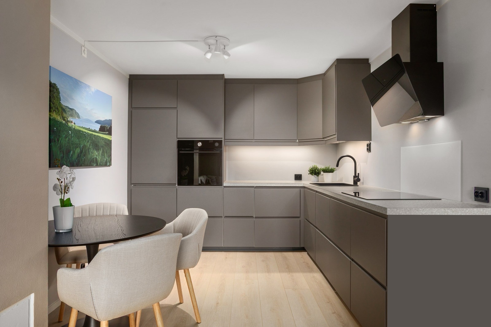 Pent kjøkken fra 2021 med over- og underskap i slette mørke fronter Galleribilde