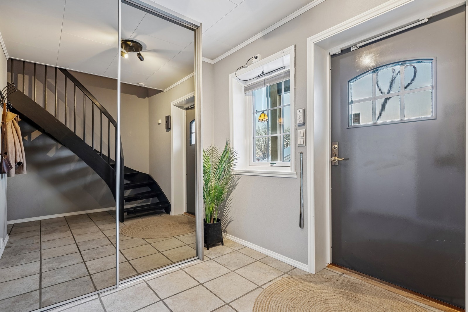 Flislagt entré med varme i gulv og praktisk skyvedørsgarderobe. Galleribilde