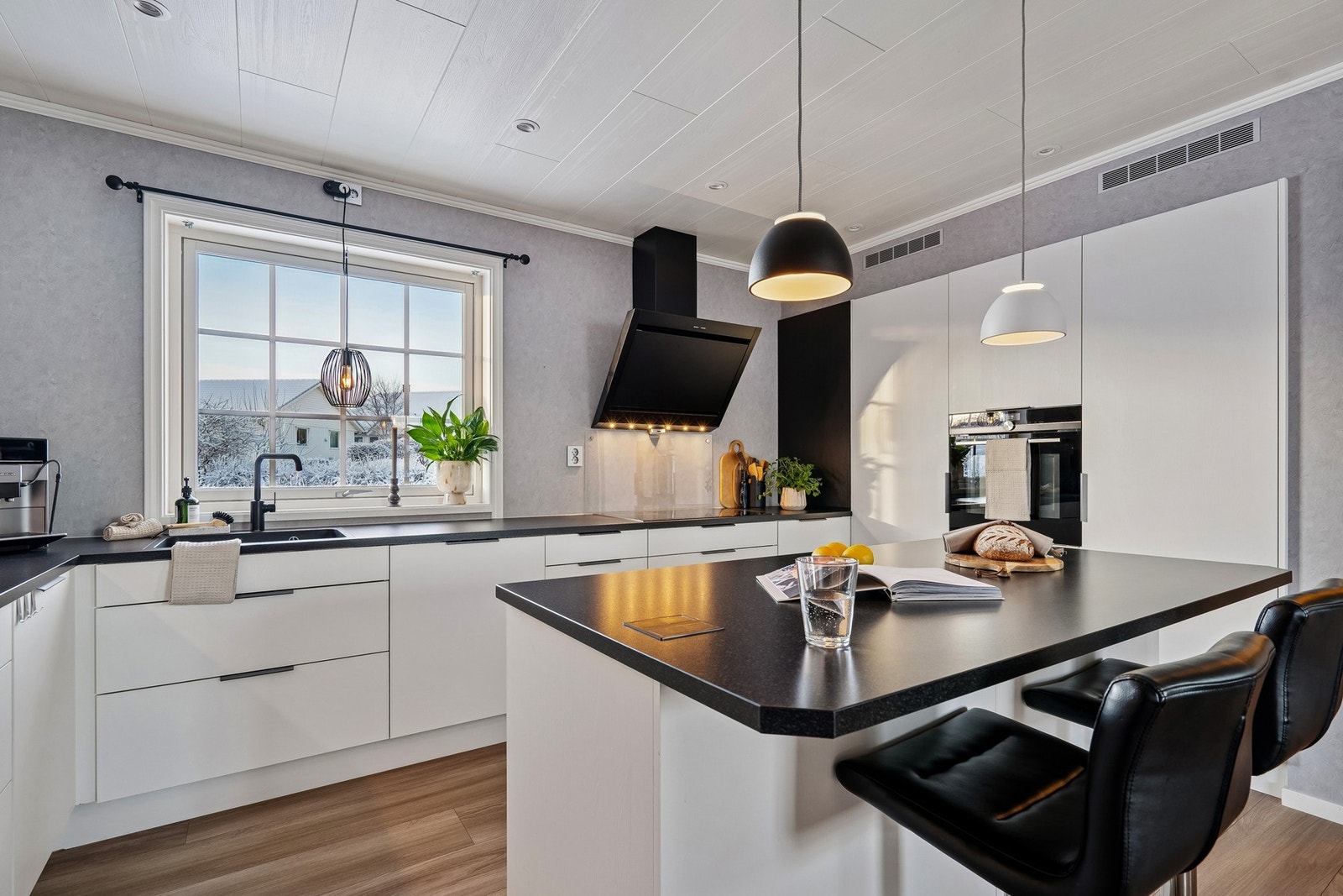 Lyst og moderne kjøkken med tidsriktige materialvalg, god arbeidsplass og praktisk kjøkkenøy - et ypperlig samlingspunkt i boligen. Galleribilde