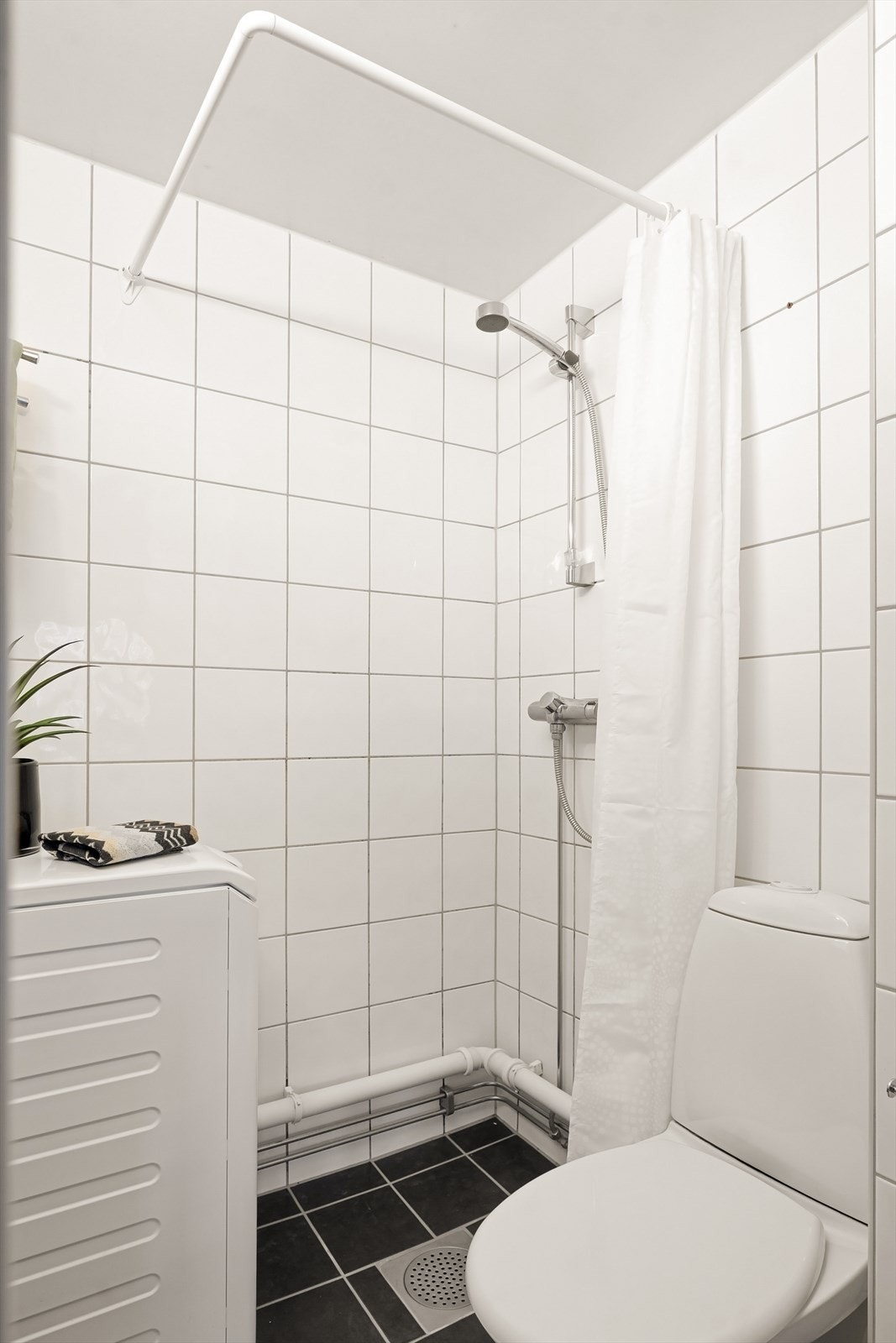 Badet har dusjhjørne og opplegg for vaskemaskin. Galleribilde