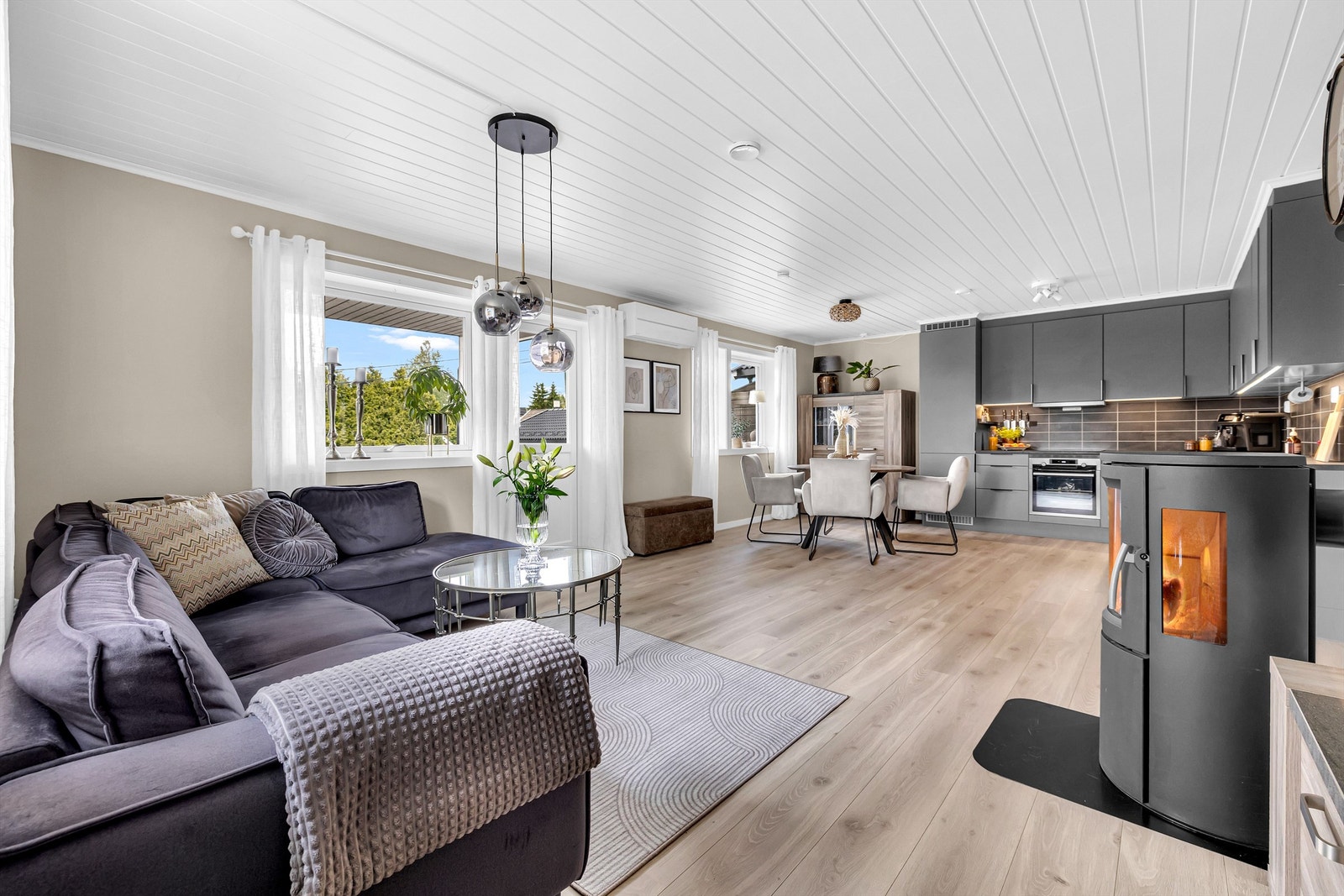 Stuen ligger i en åpen løsning med kjøkkenet, og sammen danner de et gjennomgående og innbydende allrom. Galleribilde