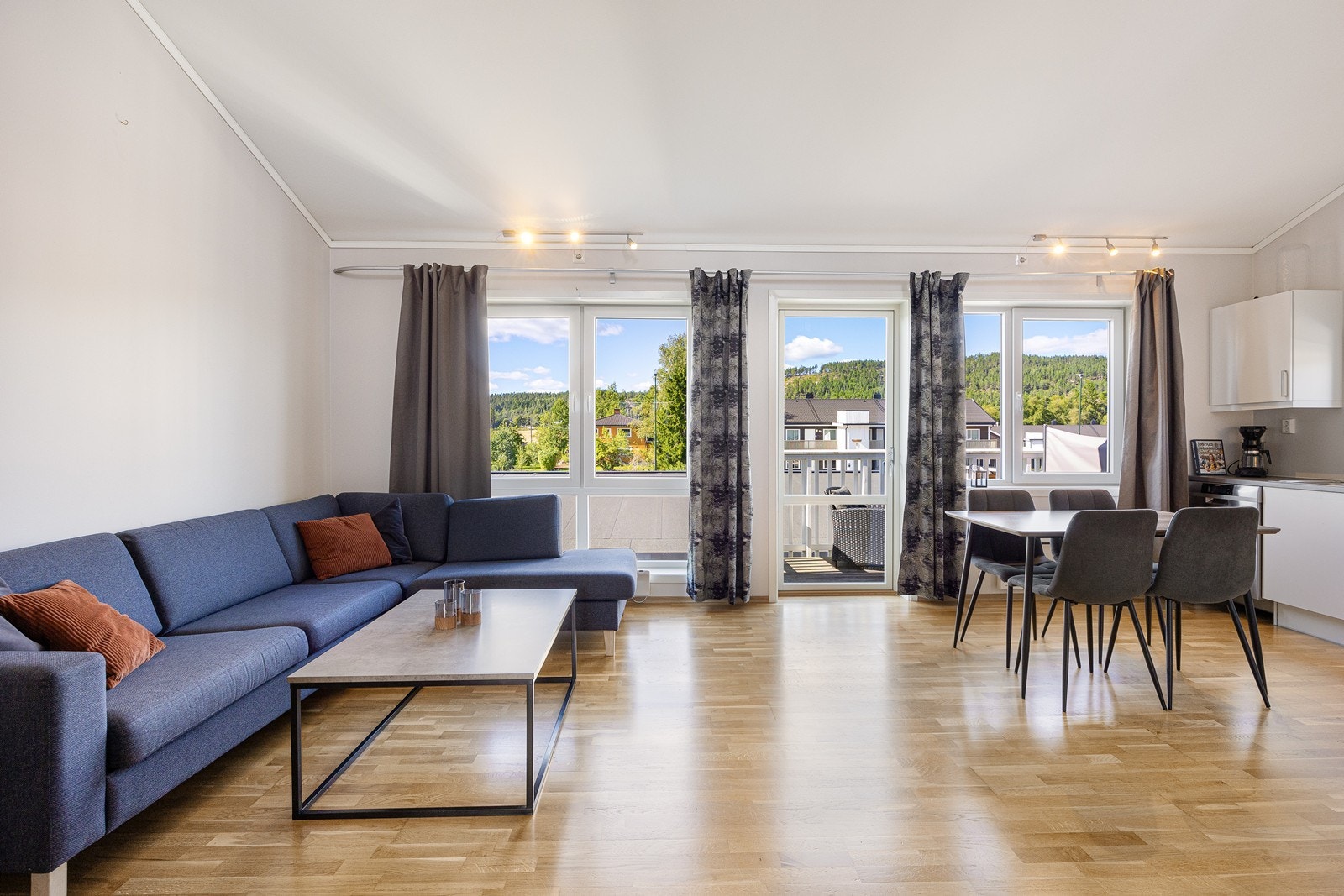 Dagslyset som strømmer inn via store, vestvendte vinduer gjenspeiles fint i de hvitmalte overflatene. Galleribilde