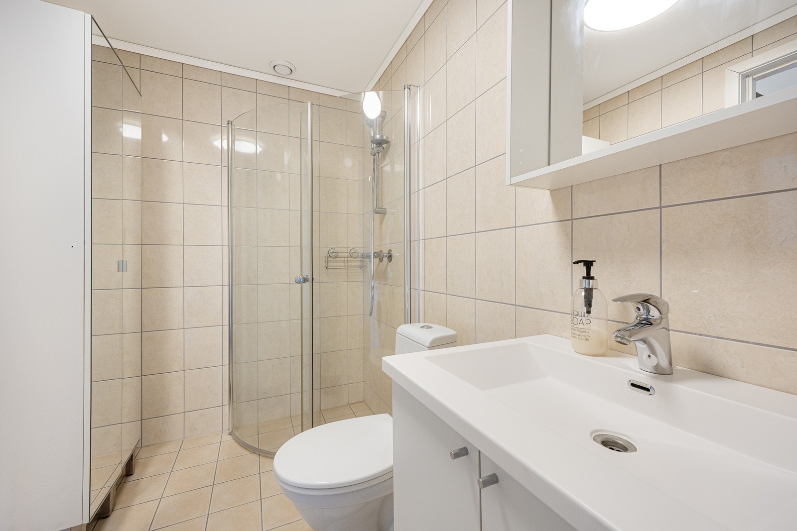 Badet har ekstra oppbevaringsplass i et romslig høyskap med speilfronter. Galleribilde